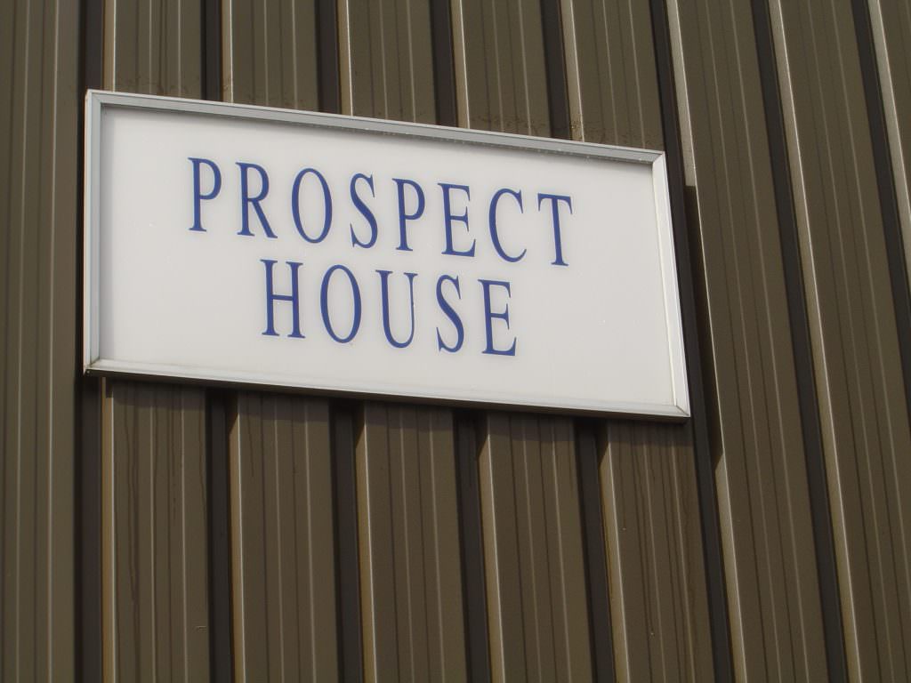 A large Building name sign, produced in self adhesive vinyl lettering.  Supplied with an aluminium frame for fitting to metal cladding