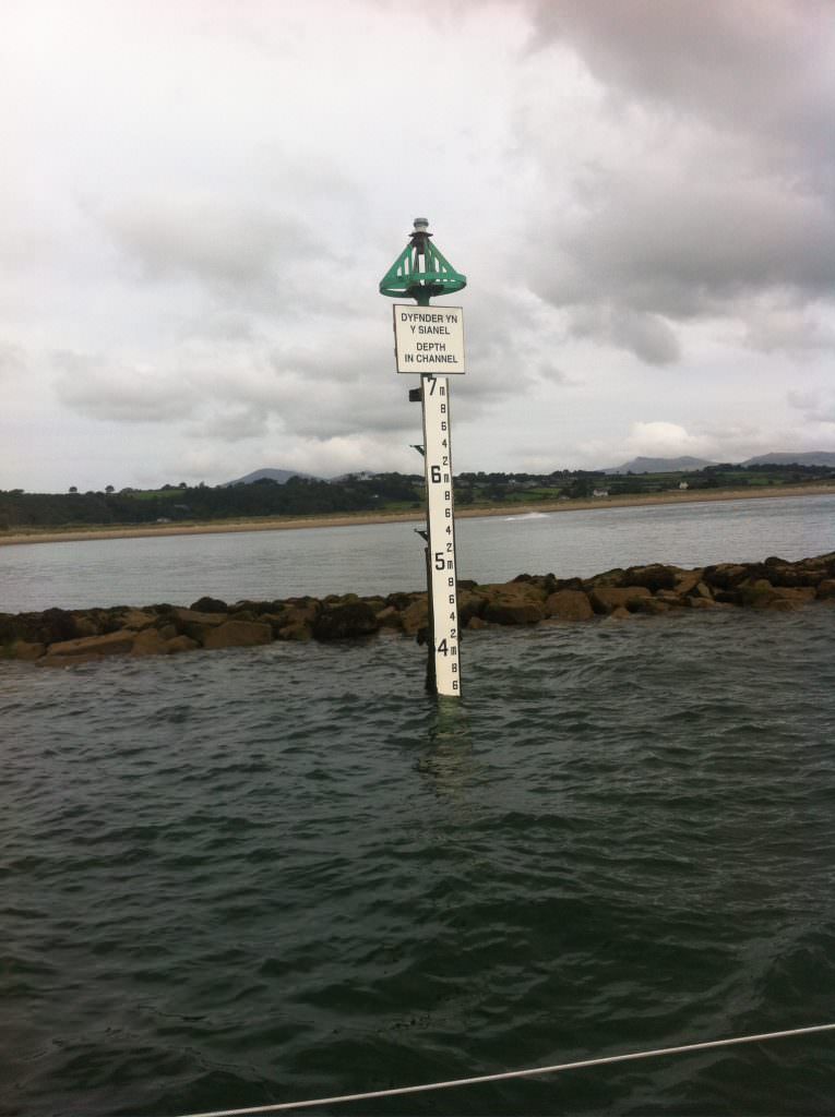 A D53 gauge board giving water height at the entrance to Pwlhelli marina. Post mounted with a depth of water plaque and a North Cardinal marker