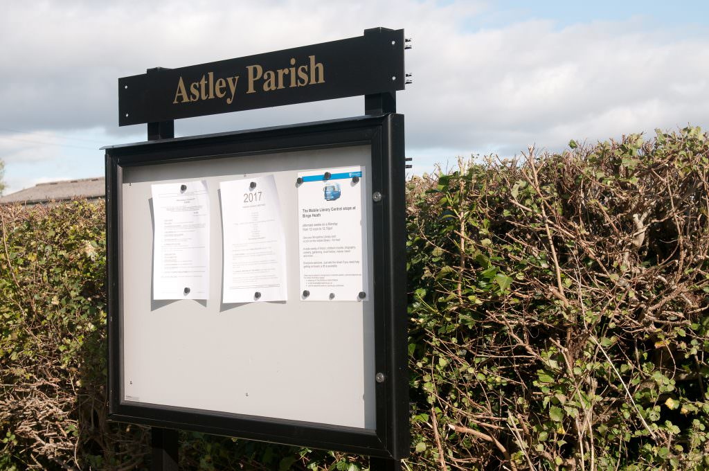 An A1 size aluminium notice board to display 8 sheets of A4 with header panel and posts. Located in a layby of a rural village.