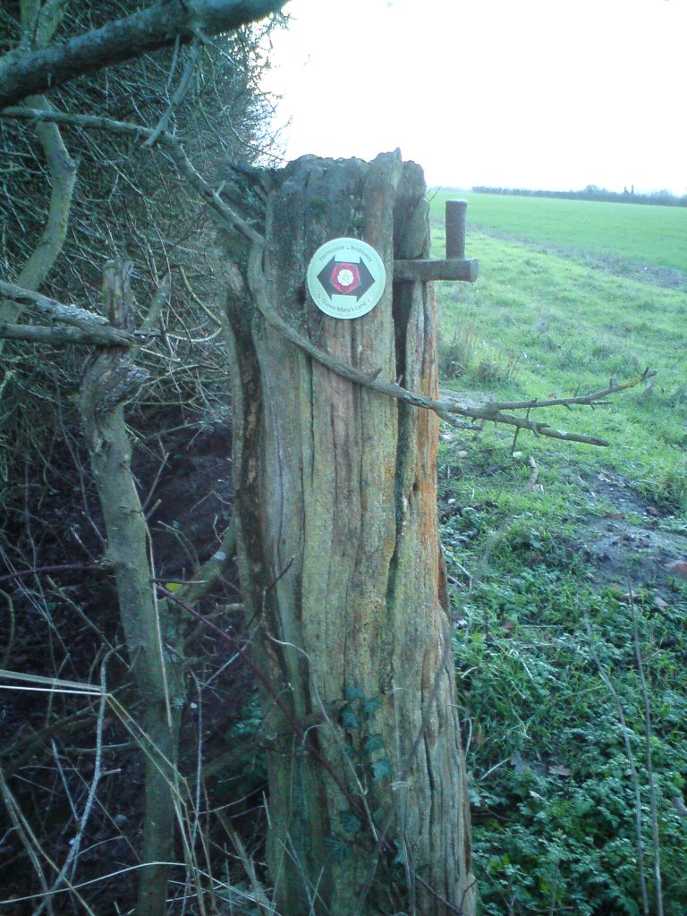 PVC waymarker disc on a timber gate post in countryside